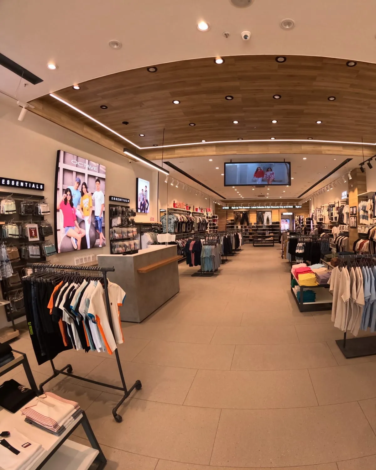 Mannequin display and folded stock against a full-height merchandising wall.